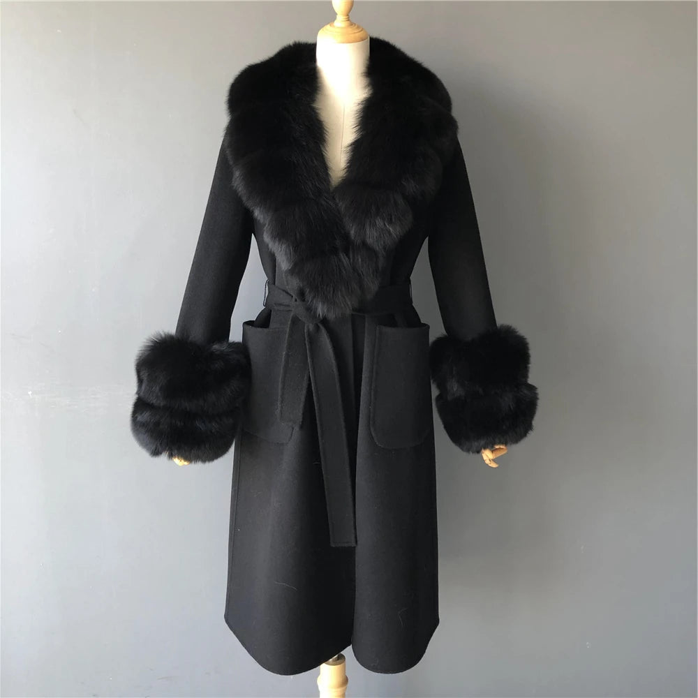 Black coat with fur trim on a mannequin against a plain background