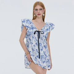 Woman wearing a blue floral dress with a white background