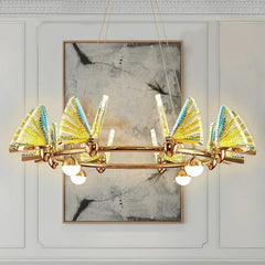 Decorative chandelier with gold and blue accents on a white wall with abstract art.