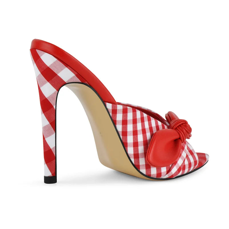 Side view of red and white gingham stiletto mule with bow detail.