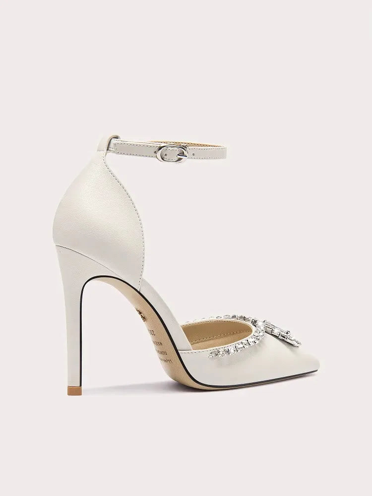 White high-heeled shoe with embellishments on a light gray background