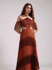 Woman wearing a brown fringe dress against a plain background