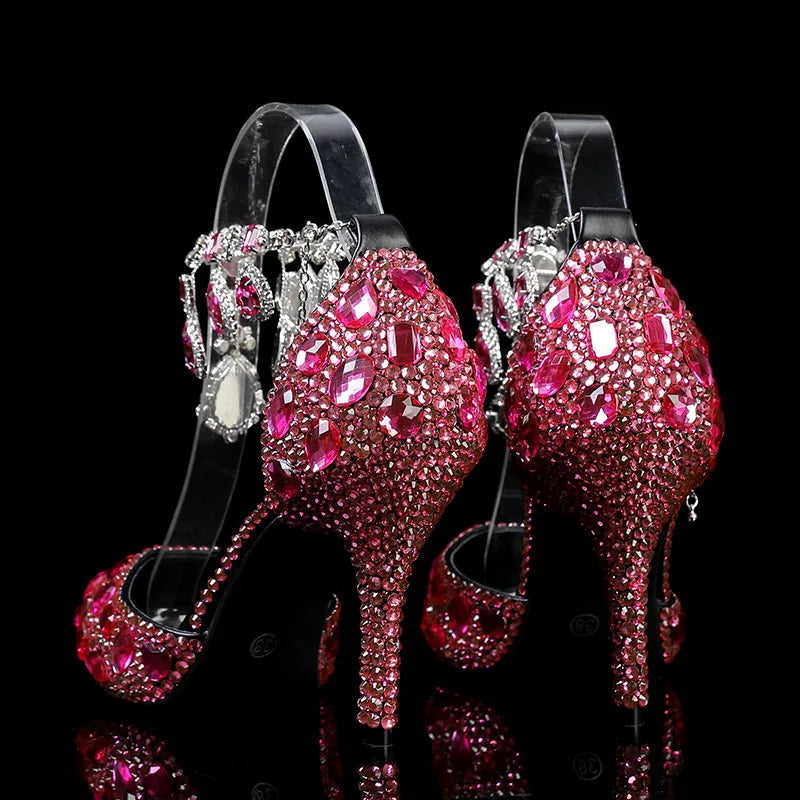 Pink high-heeled shoes with rhinestone embellishments on a black background