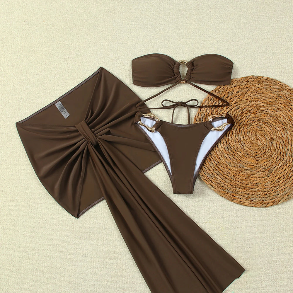 Flat lay of three-piece bikini and sarong beach cover-up set