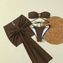 Flat lay of three-piece bikini and sarong beach cover-up set