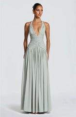 Woman wearing a light green halter neck gown on a white background