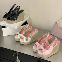 Wedge sandals with polka dot and pink designs on a metallic surface.