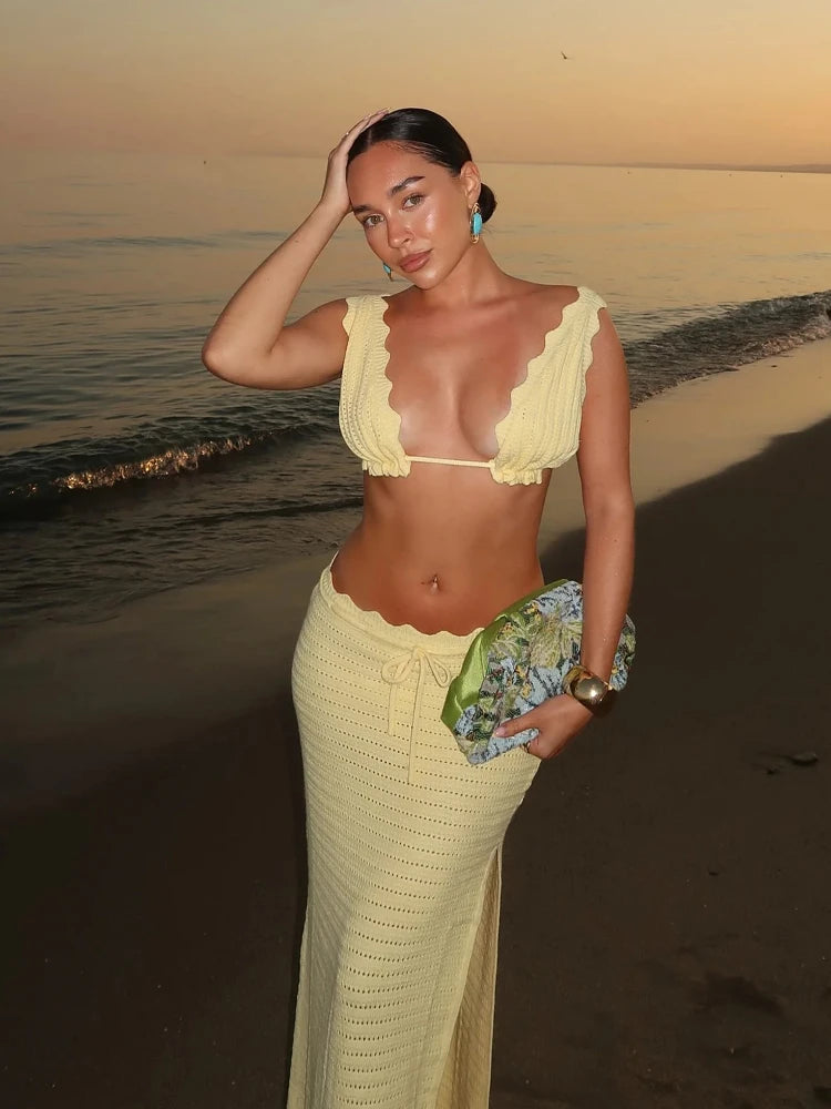 Woman in a yellow outfit on a beach at sunset