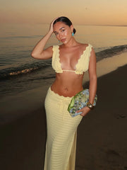 Woman in a yellow outfit on a beach at sunset