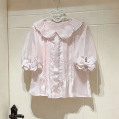 Close-up of the pink sheer puff sleeve blouse with bow cuff detail.