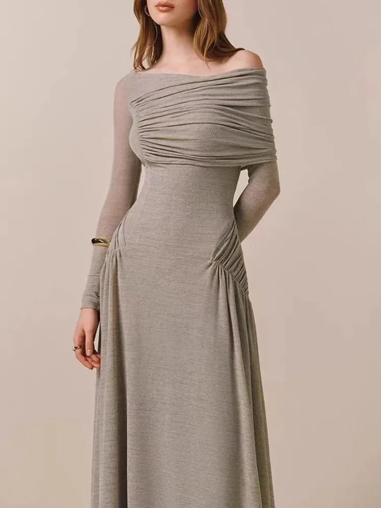 Woman wearing a long, off-shoulder dress with a neutral background