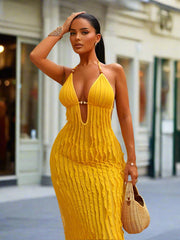 Woman wearing a yellow ribbed dress standing outdoors.