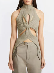 Woman wearing a green knitted top with cut-out design on a white background