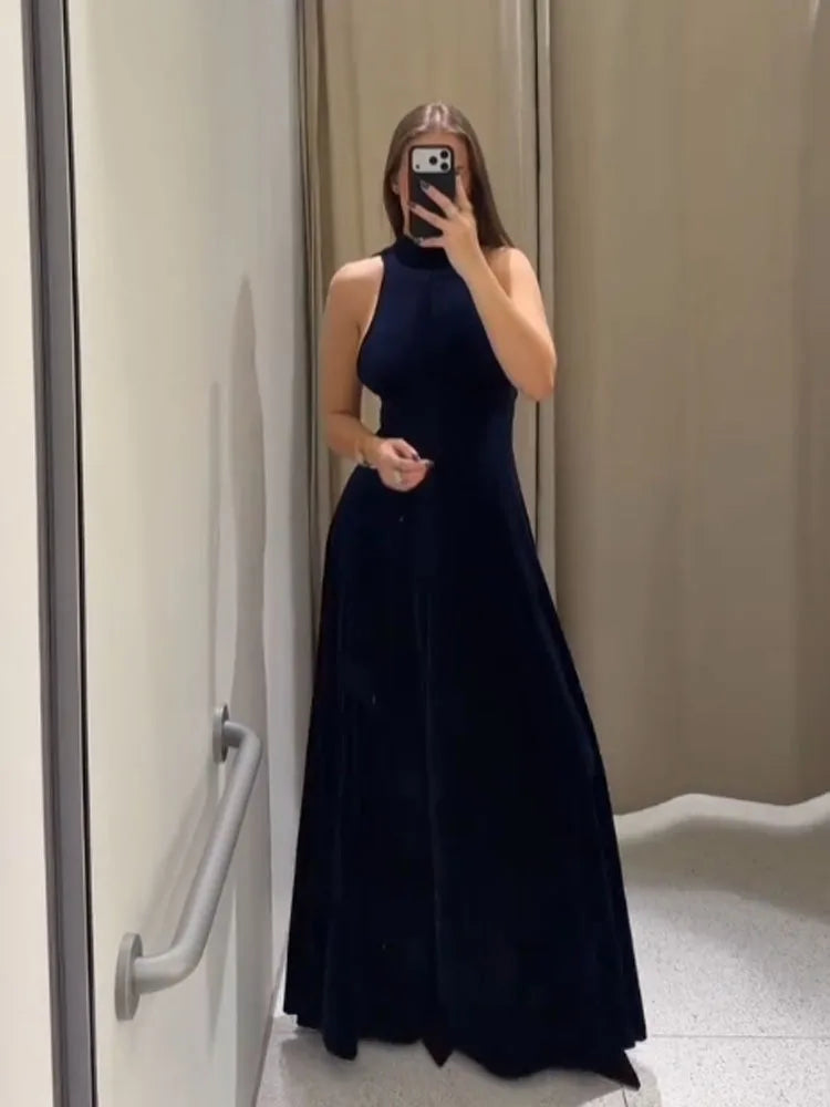 Person wearing a navy blue evening gown in a bathroom.