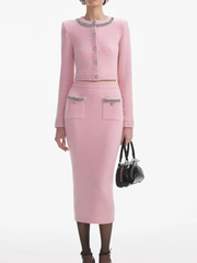 Woman wearing a pink outfit with decorative elements on a white background
