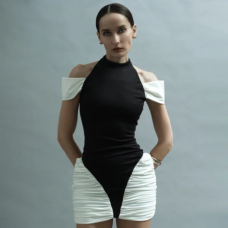 Woman wearing a black and white outfit against a gray background