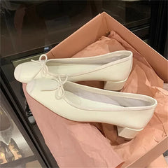 White leather ballet flats with bowknot detail in a box