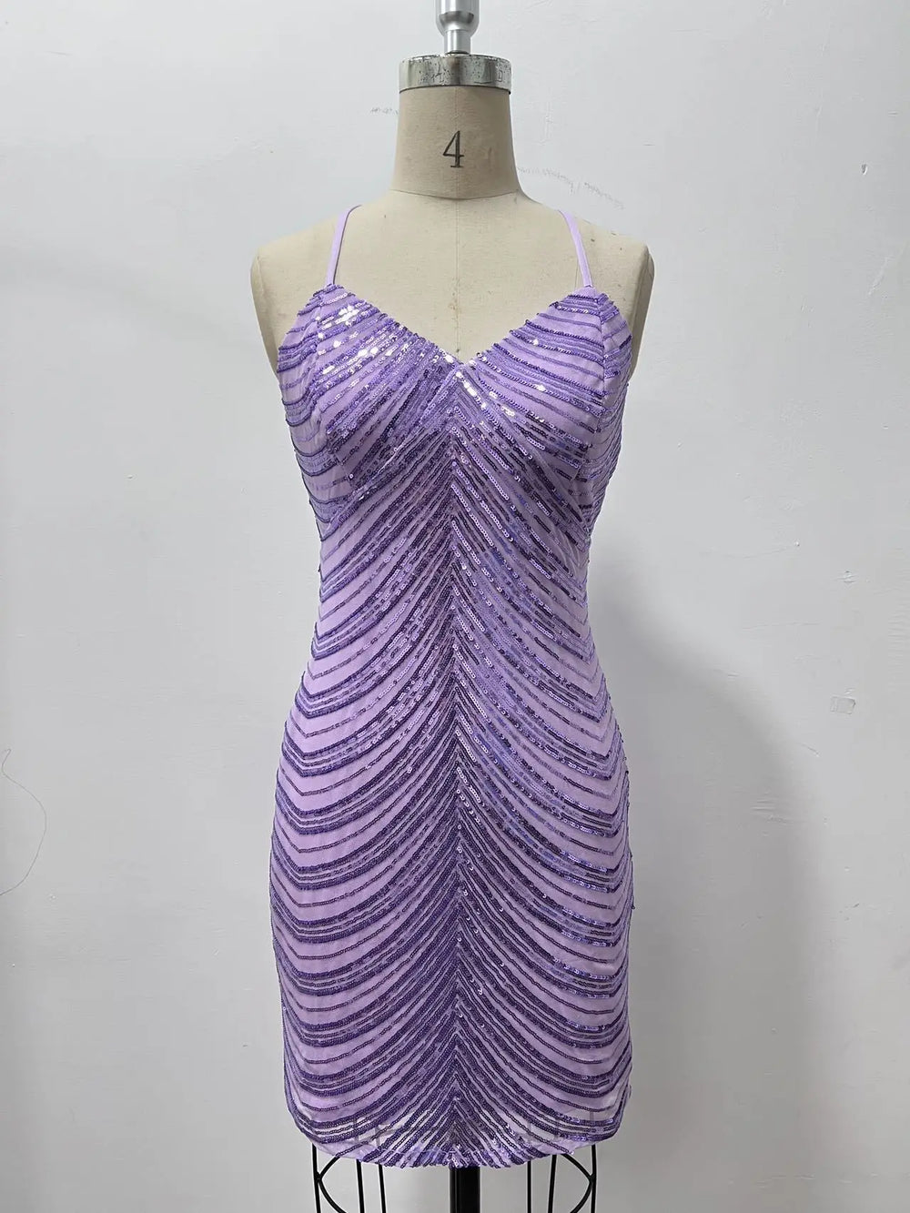 Purple sequin dress on a mannequin against a white background