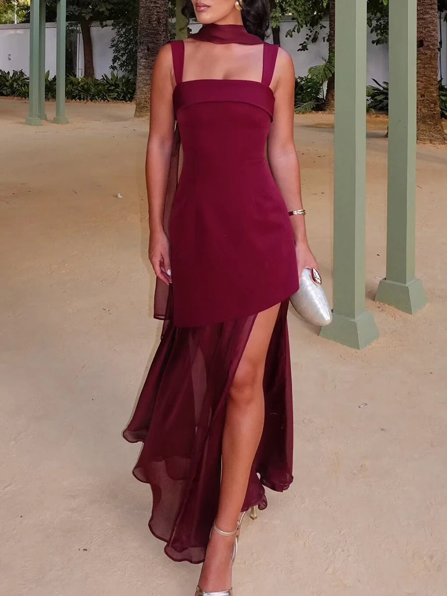 Woman wearing a burgundy dress with a slit in an outdoor setting