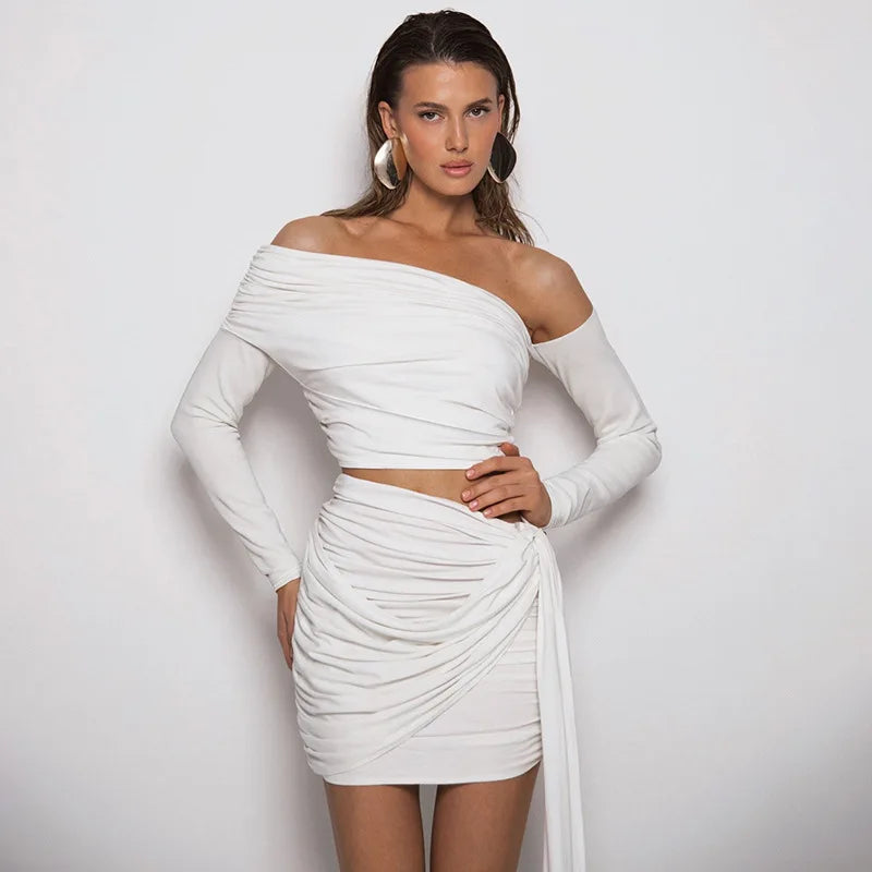 Woman wearing a white off-shoulder dress against a plain background