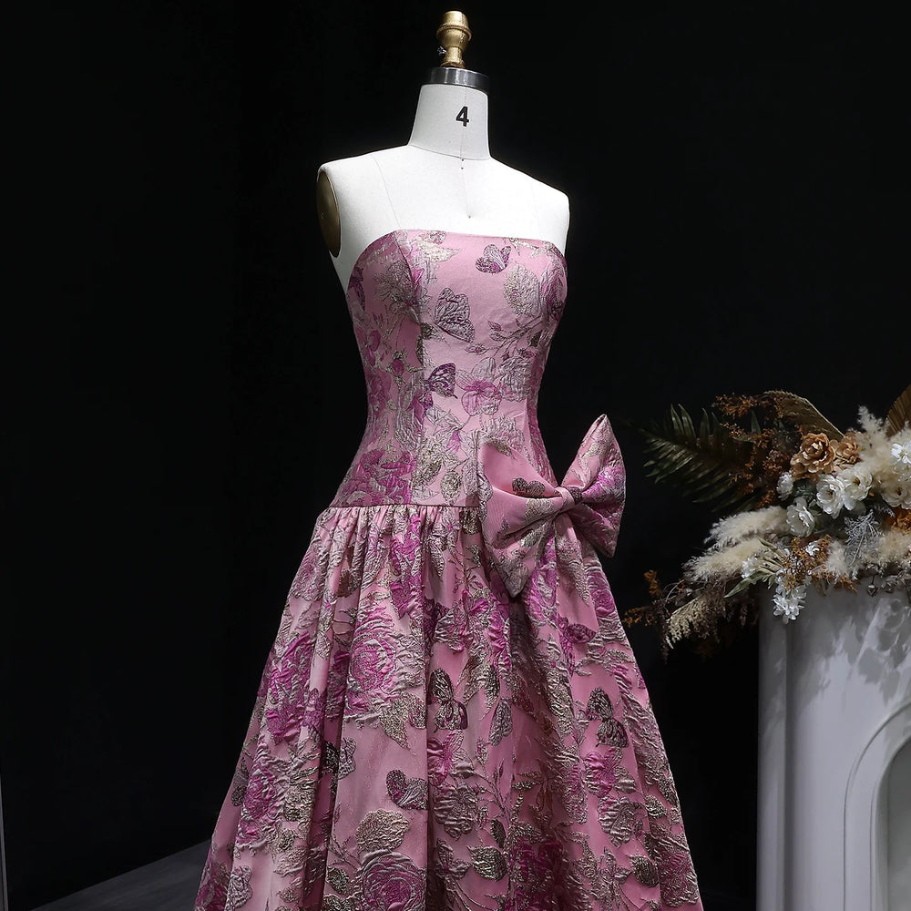Pink floral dress on a mannequin with a black background