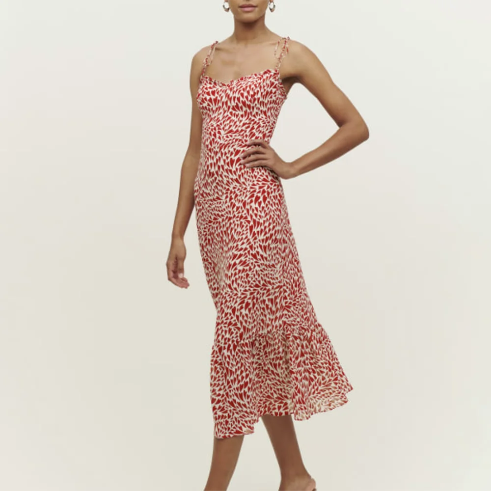 Woman wearing a red and white patterned dress on a plain background
