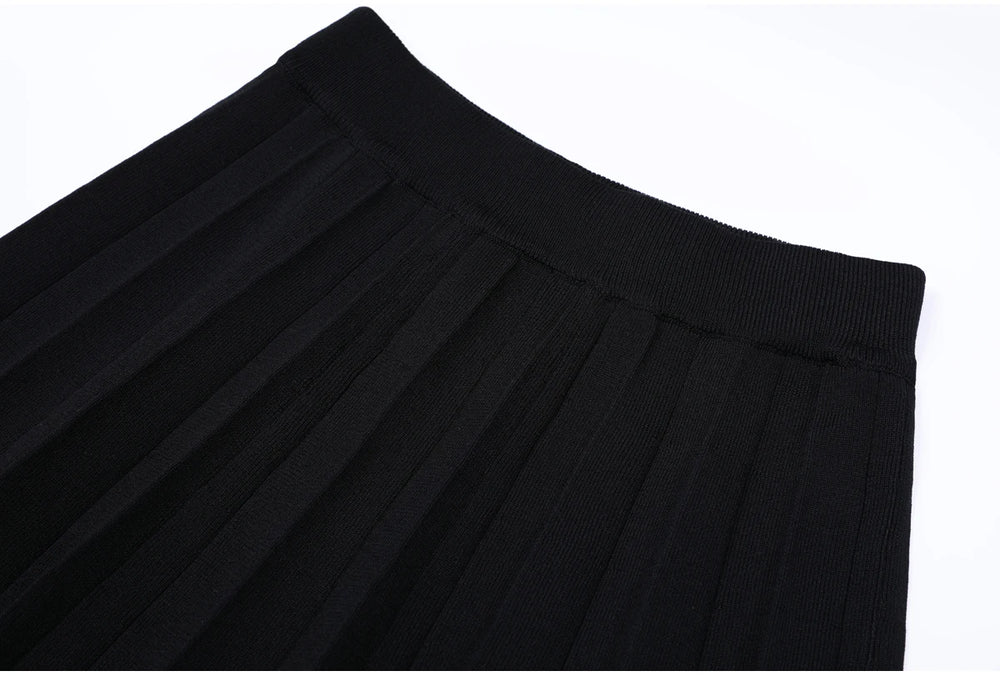Close-up of the waistband and pleats on the black midi skirt.