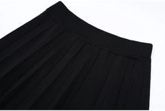Close-up of the waistband and pleats on the black midi skirt.