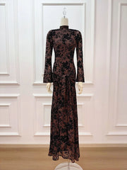 Long-sleeve dress with floral pattern on a mannequin against a white paneled wall.