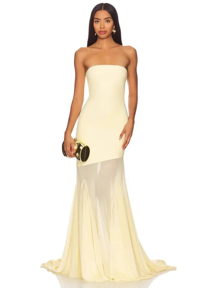 Woman wearing a strapless yellow evening gown on a white background