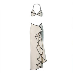 White bikini top and a white ruffled maxi skirt with black contrast trim laid flat.