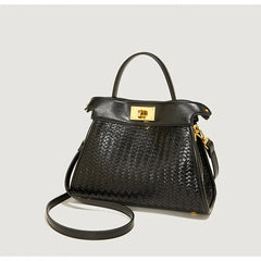 Black woven handbag with gold accents on a light gray background
