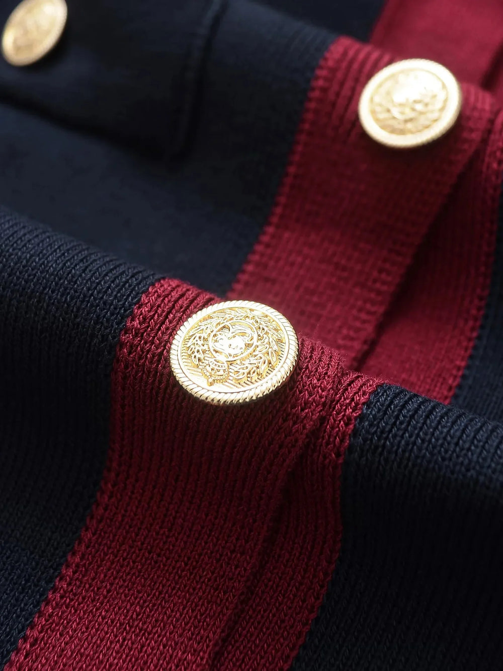 Close-up of a navy and red striped garment with gold buttons.