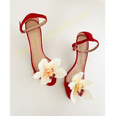 A pair of elegant rose red ankle strap heels with a delicate floral accent and a thin stiletto heel. Golden Atelier 2