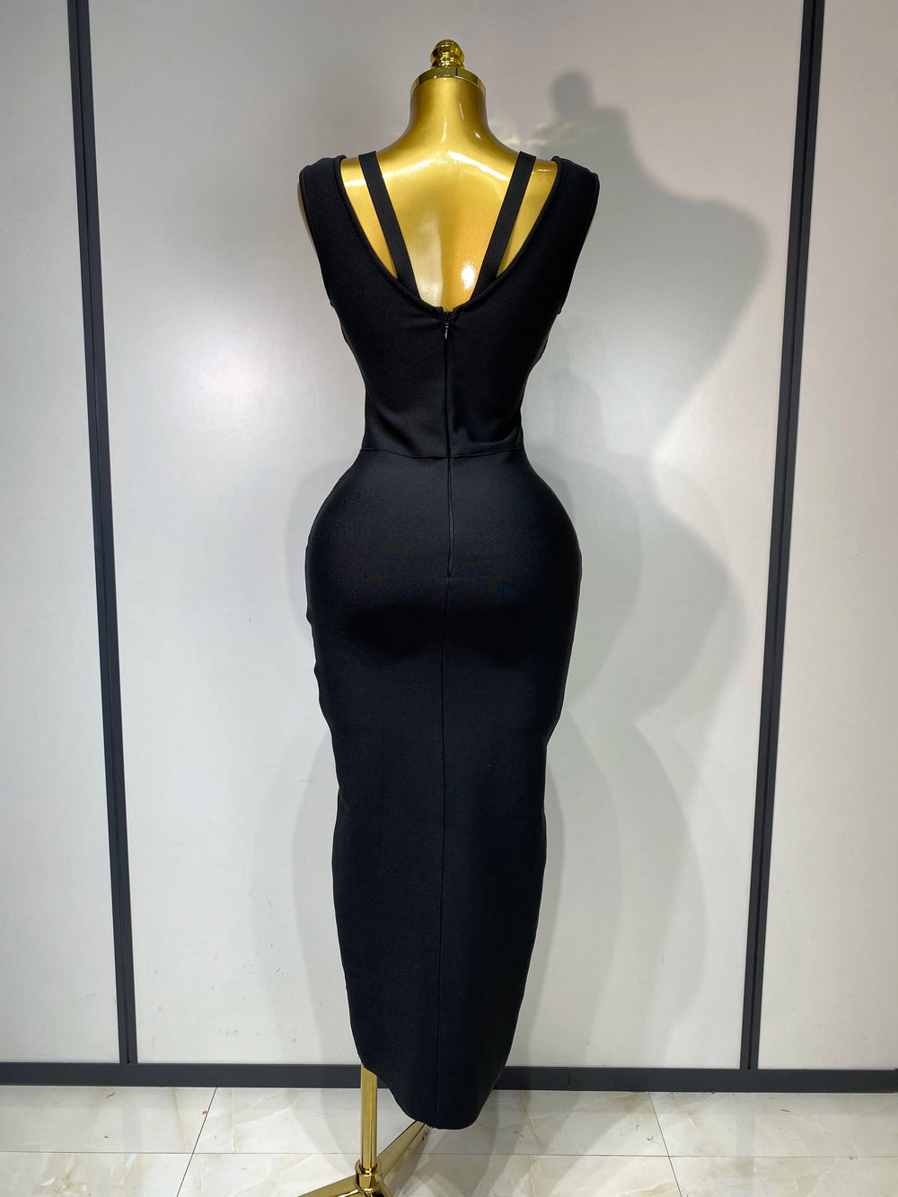 Black dress on a mannequin against a plain background