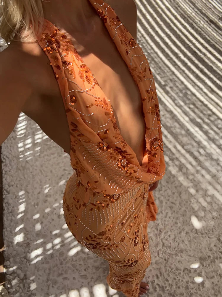 Woman wearing an orange embroidered dress with a textured background