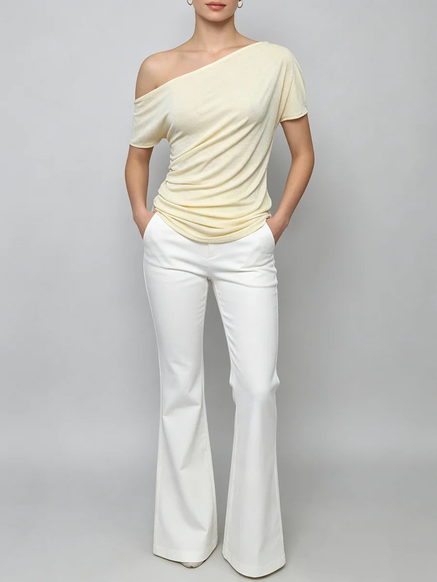 Person standing wearing a diagonal collar asymmetrical top