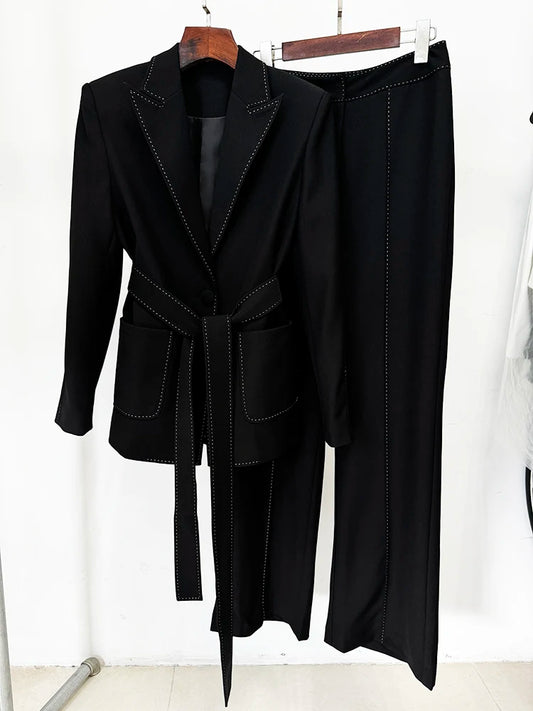 Black belted blazer and wide-leg pants suit with contrast stitching, displayed on a hanger, showing the front.