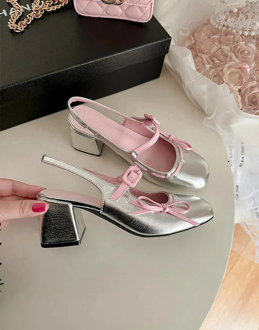 Silver patent leather chunky Mary Jane heels with pink trim and bowknot detail.