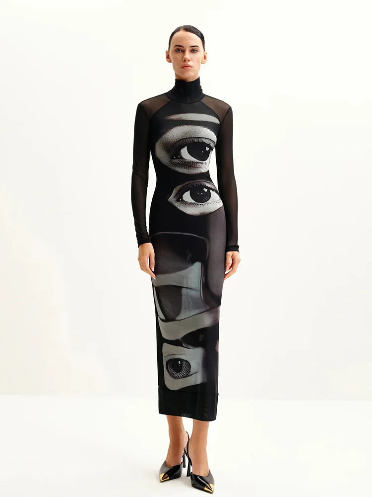 Model wearing a black dress with eye designs on a white background