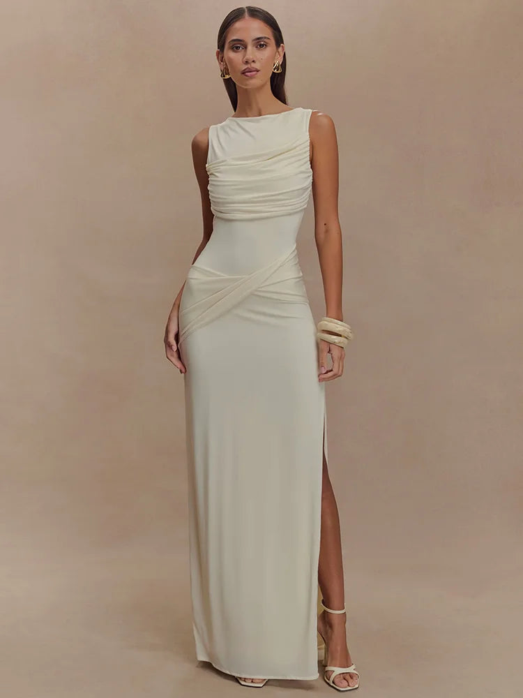Woman wearing a white sleeveless gown with a slit on a beige background