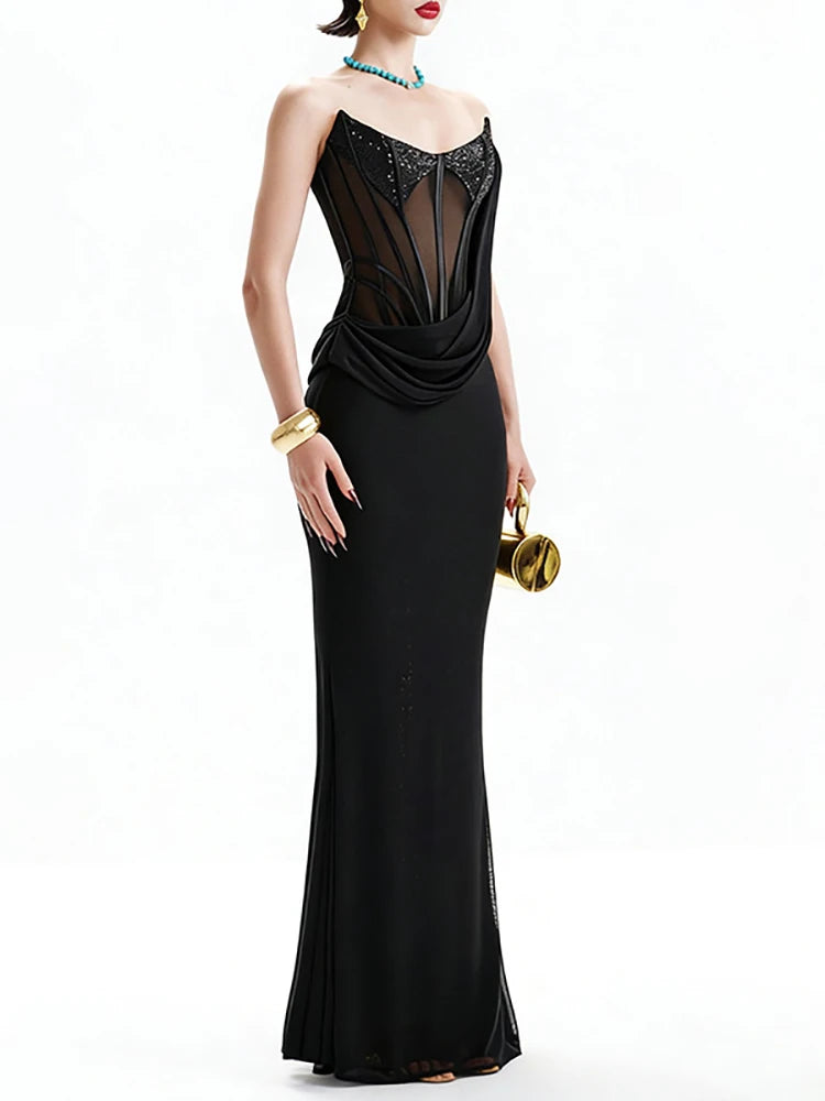 Black evening gown with intricate detailing on a white background