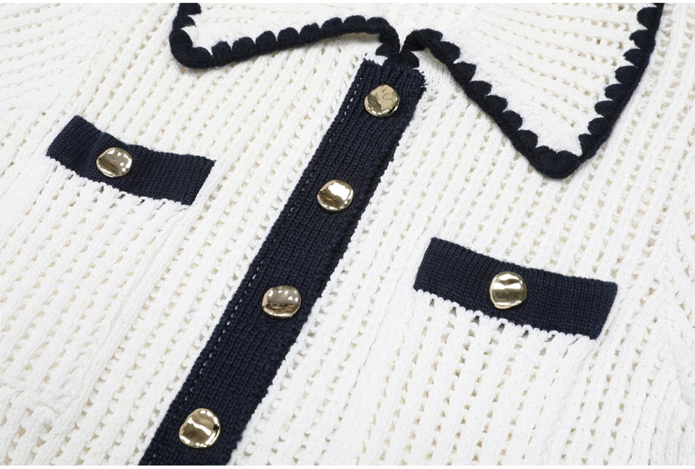 Detail of the button placket and chest pockets on a white knit top