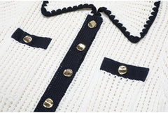 Detail of the button placket and chest pockets on a white knit top