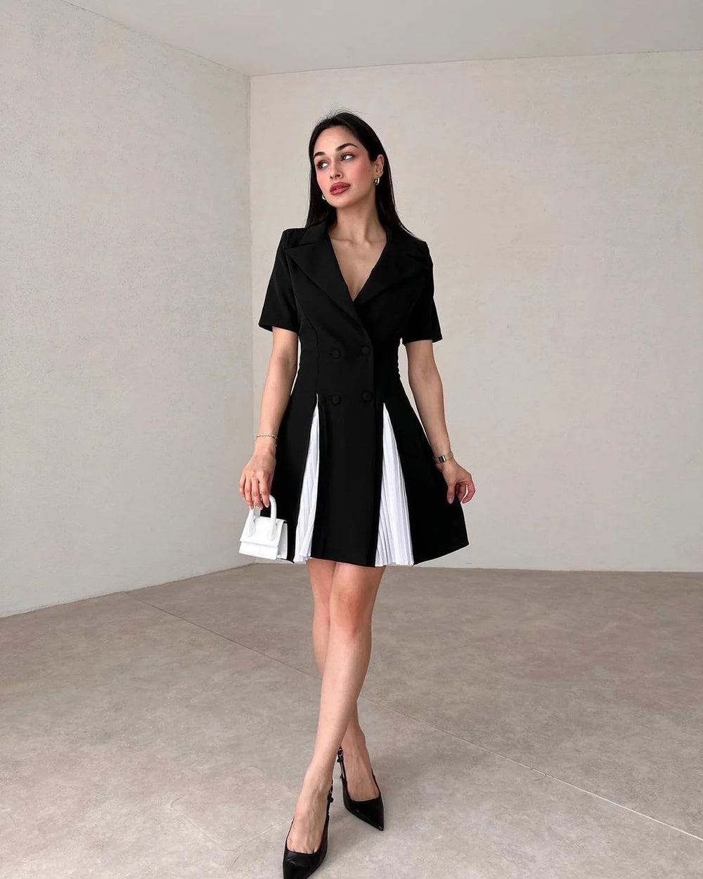 Woman wearing a black and white dress in an indoor setting