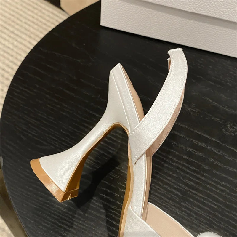 White high-heeled shoes on a dark textured surface
