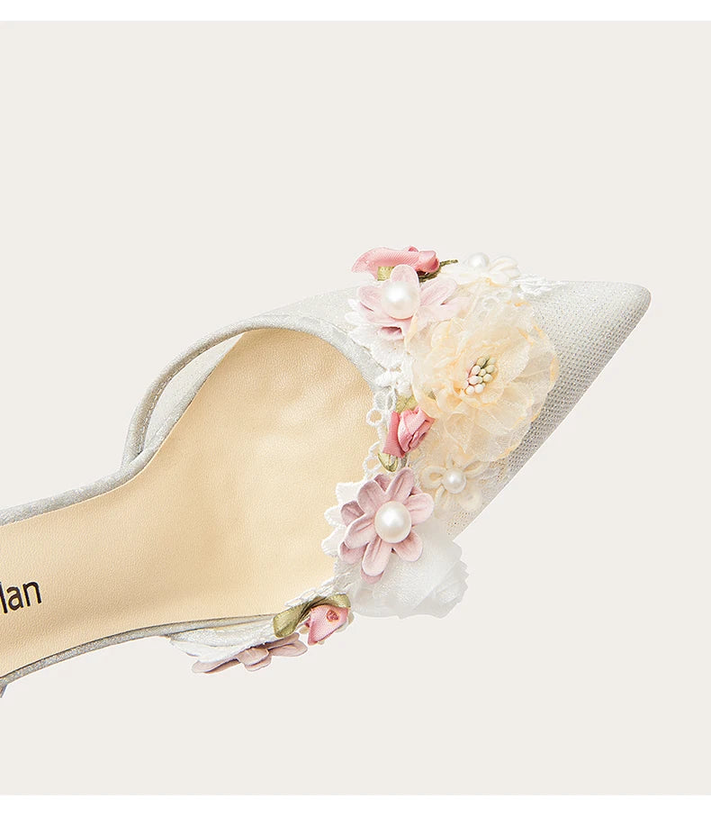 High-heeled shoe with floral and pearl details on a white background