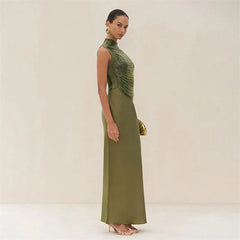 Woman wearing a green evening gown with a plain background