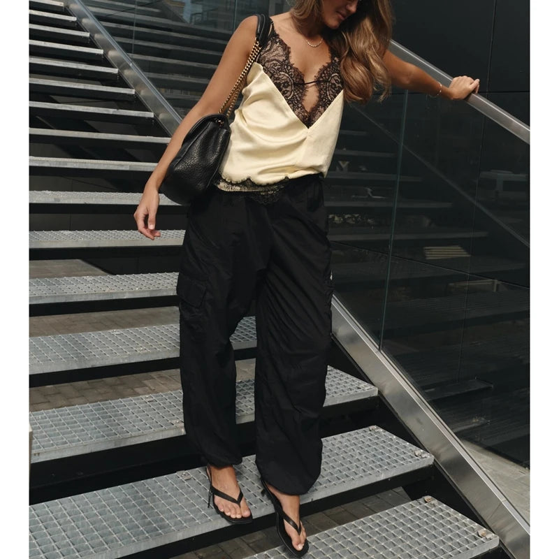 Person wearing a stylish outfit with a black bag on a staircase.