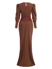 Brown evening gown with long sleeves and a red belt on a white background